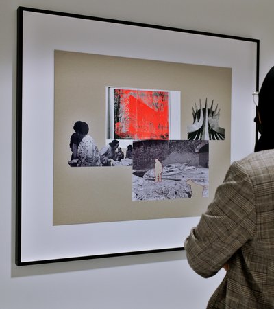 Woman in hijab looking at a collage artwork in a museum