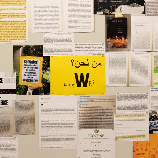 A collection of documents surround a yellow paper in the middle that has 'Who is We?' written on it.