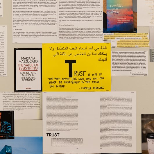 A collection of documents surround a yellow paper in the middle that has the word 'Trust' written on it.