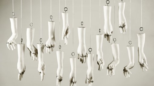 Nayla Ahmed and Federica Visani's artwork, featuring silicone hands that are hanging from the ceiling, wearing jewellery.