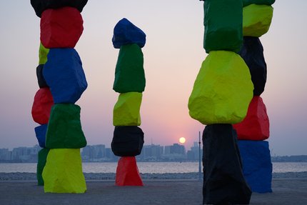 Vertically stacked rocks in bright red, blue, green, yellow and black.