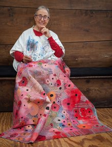 An old woman working on one of her artworks.