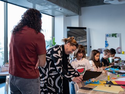 Two adults discussing kids artwork at a workshop