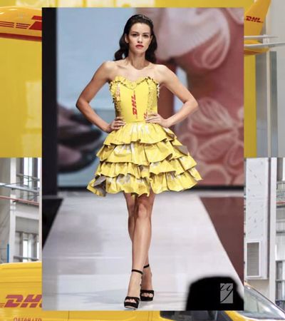 امرأة تمشي على منصة عرض أزياء مرتدية فستانًا من DHL