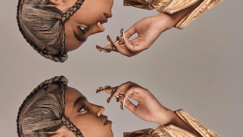 Mirror of a model wearing gold jacket and couture braids