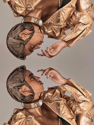 Mirror of a model wearing gold jacket and couture braids