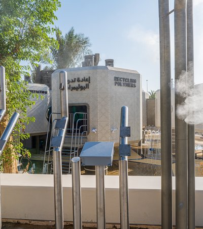 Picture of a recycling plant themed playground, at the background is a tower and written on top of it is ''recycling polyesters''