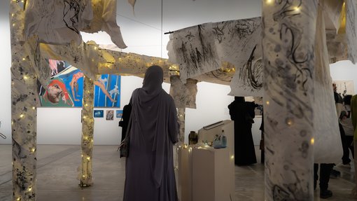 woman back looking at hanging fabric installations