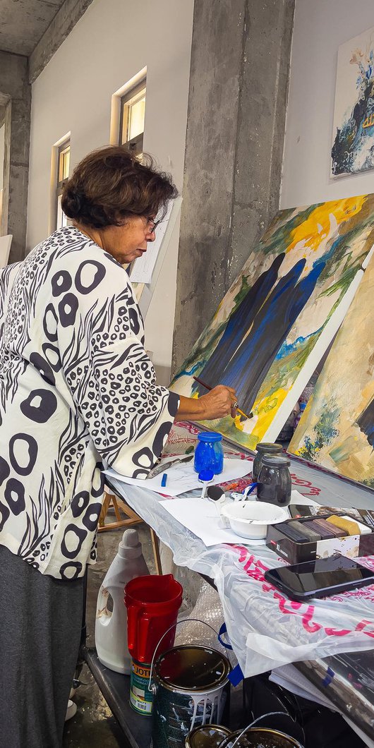 Ruwad Artist Wafika Sultan Al-Essa working in the corner of her studio at the Fire Station.