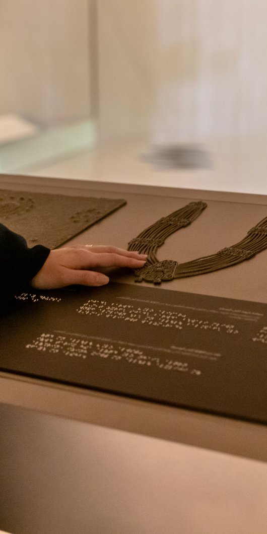 Woman using tactile accessible information panels at NMoQ