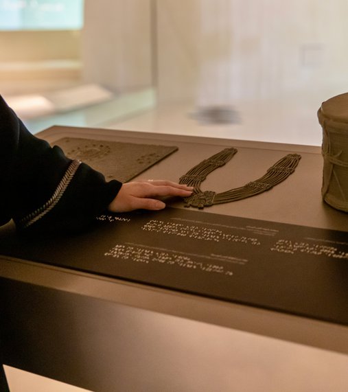 Woman using tactile accessible information panels at NMoQ