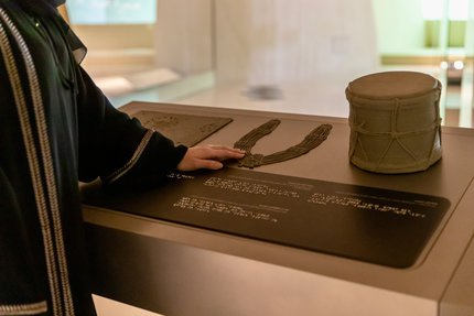 Woman using tactile accessible information panels at NMoQ