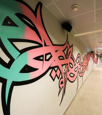 A long shot of a hallway in Lusail decorated with El Seed's mural art