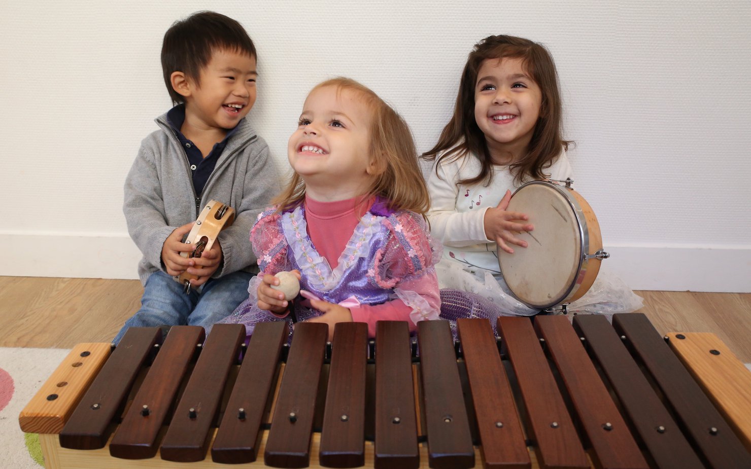 Three children holding music instruments