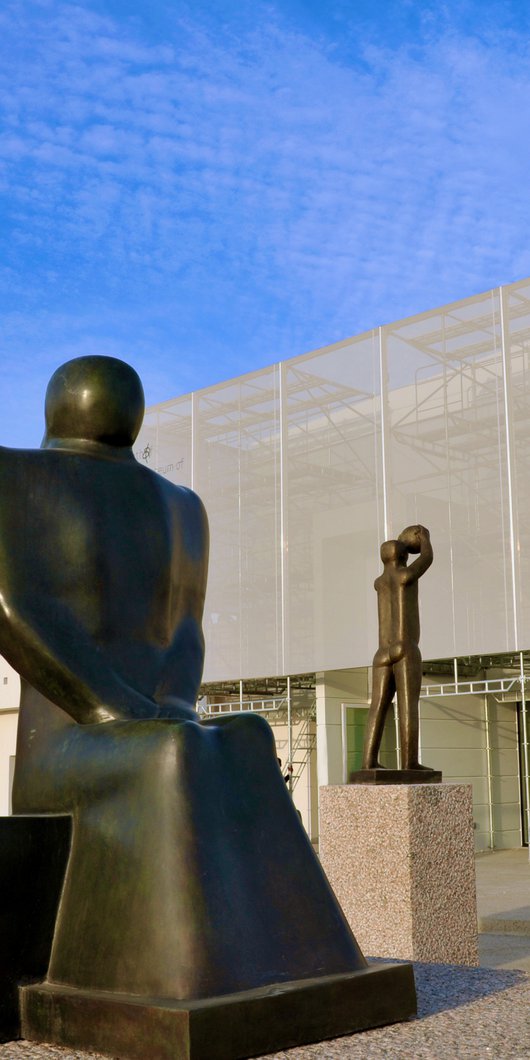 Exterior view of Mathaf: Arab Museum of Modern Art building with a group of three large sculptures positioned in front of it