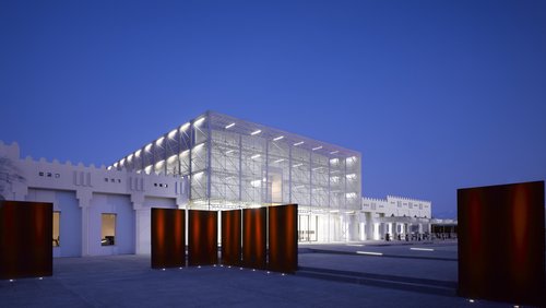 Exterior view at nighttime showing Mathaf's contemporary building brightly lit