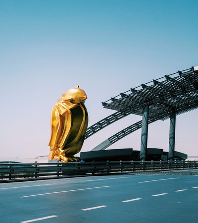 Bright gold-coloured sculpted falcon on the side of the road leading to Hamad International Airport