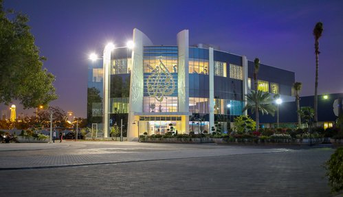 The outside of a building with the Al Jazeera logo mounted on the front.