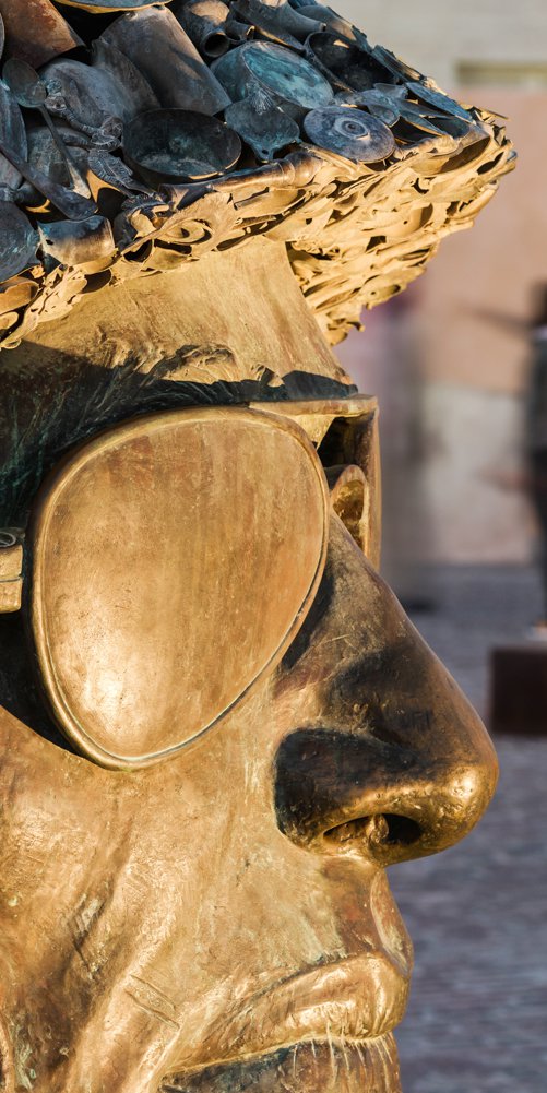 A focus on the sculptures wearing a soldier’s helmet and the other wearing a face cover