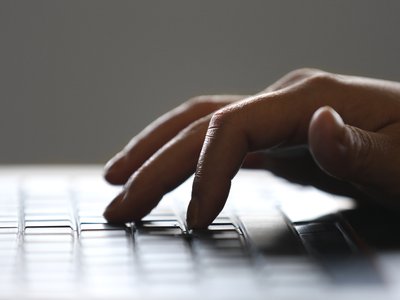 A close-up view of a hand typing on a keyboard