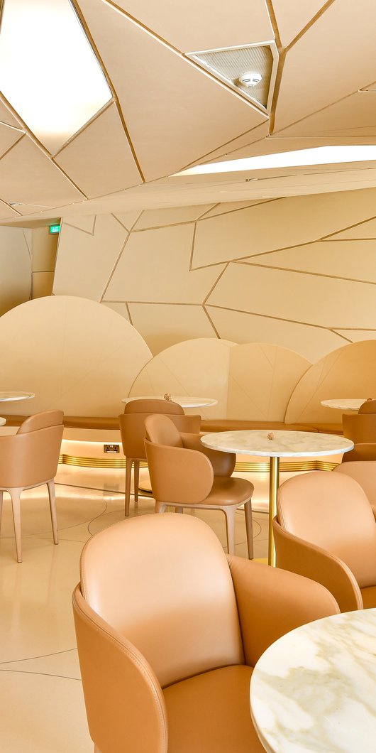 View of the interior of the Desert Rose cafe showing tables and chairs and the faceted shapes of the NMoQ building