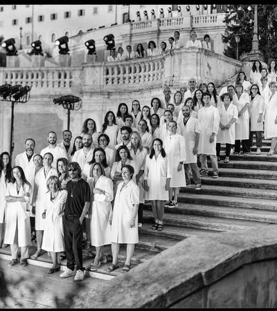 A group of people in white coats standing on the Spanish Steps in Rome.