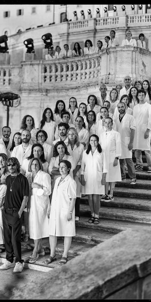 A group of people in white coats standing on the Spanish Steps in Rome.