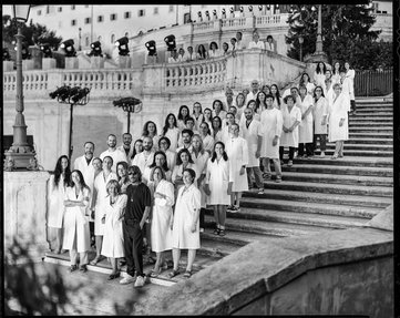 A group of people in white coats standing on the Spanish Steps in Rome.