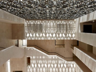 An interior shot of the M7 with light shining on intermingled staircases and fawn colours of the museum