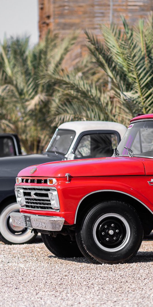 A row of classic cars parked in bright daylight for the Mal Lawal exhibition