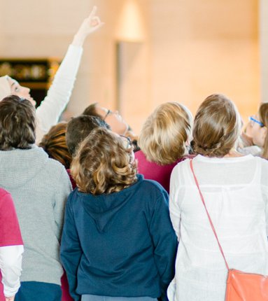 A teacher surrounded by children is giving a school tour at the Museum of Islamic Art