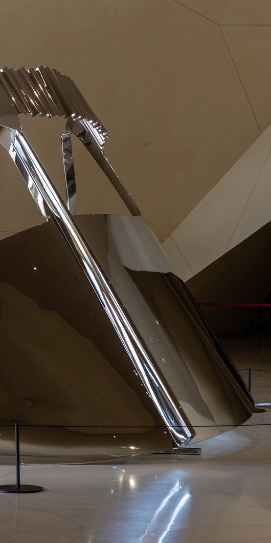 Large-scale shiny silver metallic sculpture depicting a 'niqab', a traditional face covering