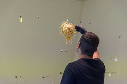 Conservator checking a round gold object