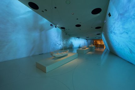 Interior of a gallery space at the National Museum of Qatar showcasing traditional dhow boats