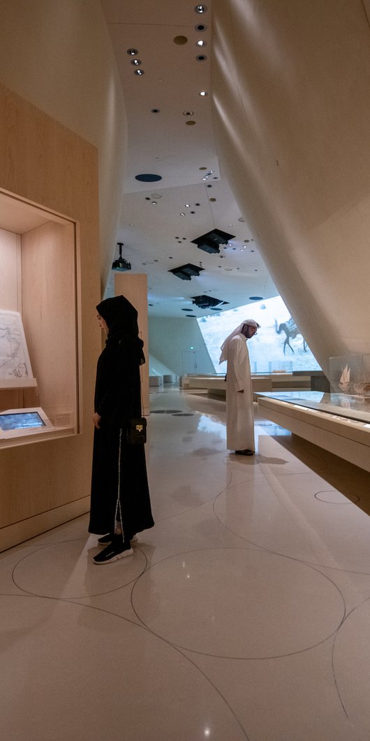 A man and a woman observing the gallery space at the National Museum of Qatar