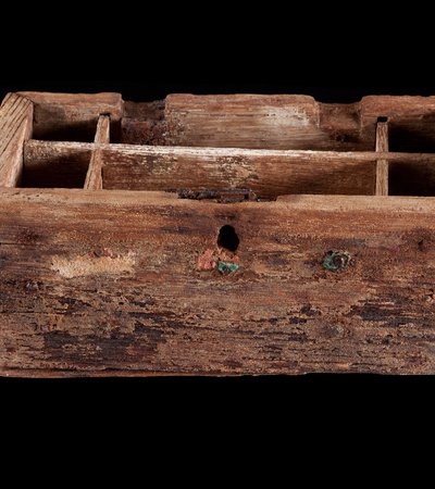 The exterior of a pearl box, made of wood, against a black background