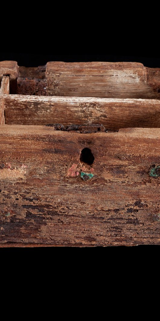 The exterior of a pearl box, made of wood, against a black background