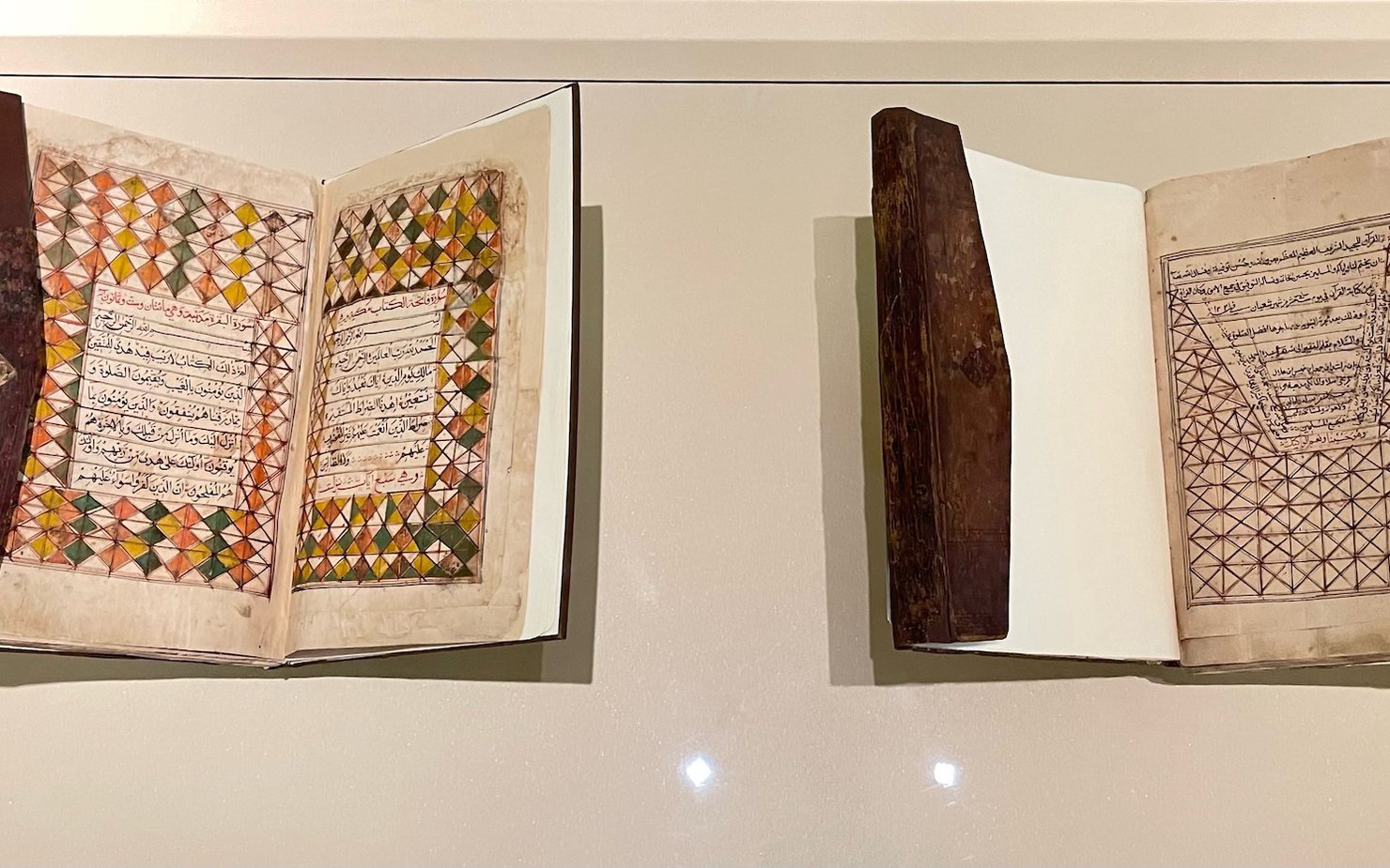 Two manuscripts behind a display case at the National Museum of Qatar