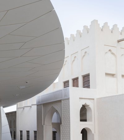 A close view of NMoQ's disks with the sculpted arches of the Old Palace visible in the background