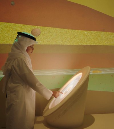 Qatari boy interacting with a digital display at the National Museum of Qatar