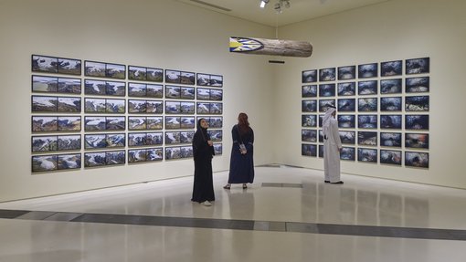 A gallery space showcasing a selection of landscape photography between two walls.