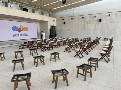 An open air space with a large projection screen and rows of empty seating.
