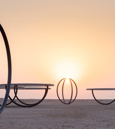 Circular shelters and rings placed in a desert landscape