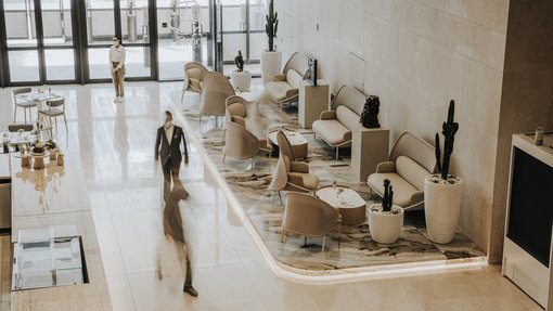 Viewed from above, a seating area with modern furniture and several staff.