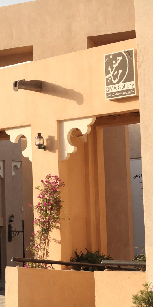 A medium shot showing the arches and traditional clay walls of the gallery's facade