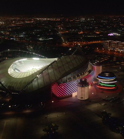 A night time image of QOSM flanked by Khalifa International Stadium