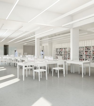 A long shot of the Mathaf library showing three men walking through the desks and bookshelves filled with multiple books