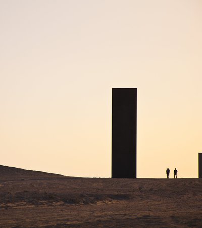 A wide shot of Richard Serra's East-West-West-East at sunset