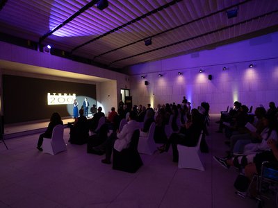 An evening event at M7's Sky Theatre with presenters and seated audience.