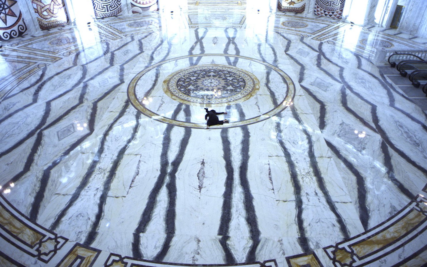 Woman shown splayed against black and white marble floor.